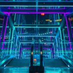 A vibrant and colorful illuminated escalator with a modern architectural design.