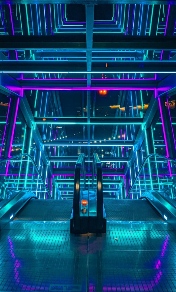 A vibrant and colorful illuminated escalator with a modern architectural design.
