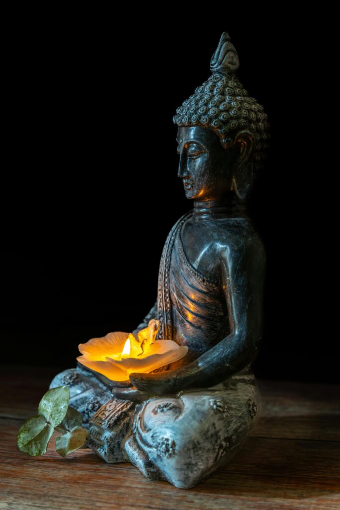 A serene Buddha statue holding a candle, symbolizing peace and spirituality.